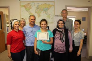 Cindy Bozkaya (center), with tutors Kathleen Kinnish (second from left) and Peter Doty (second from right), and members of her family.